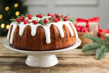 İçerideki ahşap masada kremalı, kızılcıklı ve biberiyeli nefis Noel pastası, yakın plan. Bokeh etkisi