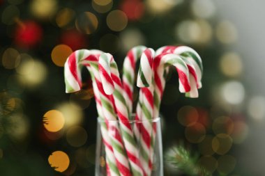 Bulanık ışıklara karşı cam çubuk şekerler, yakın çekim ve bokeh etkisi. Noel hediyesi