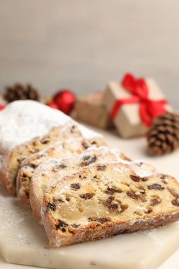 Geleneksel Stollen pastasını ve Noel dekorunu beyaz masada kes, yakın plan.