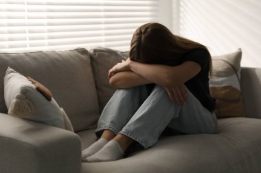 Evdeki kanepede depresif genç kız.