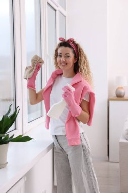 Camları paçavra ve deterjanla temizleyen kadın.