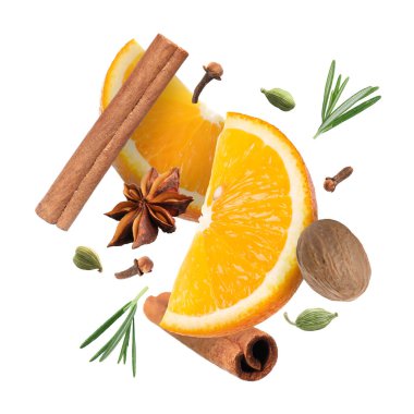 Sıcak şarap malzemeleri: beyaz zemine düşen portakal dilimleri ve baharatlar. Geleneksel Noel içkisi