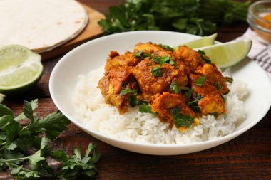 Pirinçli tavuk tikka masala, ahşap masada servis edilir, yakın plan.