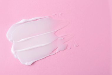 Pembe arka planda nemlendirici krem örneği. Metin için boşluk