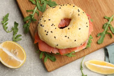 Somon, roka ve limonlu lezzetli simit gri masada, düz yerde.