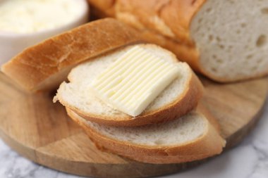 Beyaz mermer masada tereyağlı baget dilimleri, yakın plan.