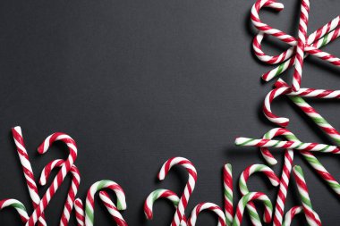 Siyah arka planda şeker kamışları, metin için yeri olan düz yataklar. Noel hediyesi