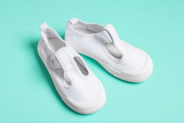 Turkuaz arka planda şık çocuk ayakkabıları, yakın plan.