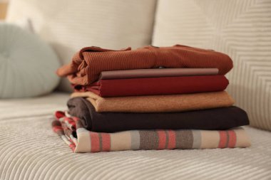 İçerideki kanepede temiz kıyafetler yığını, yakın plan.