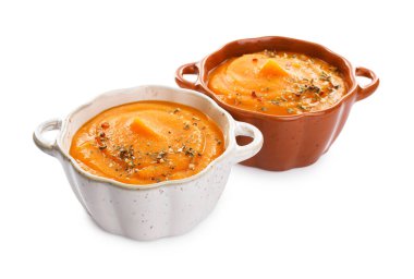 Balkabağı şekilli kâselerdeki lezzetli balkabağı kreması çorbası beyaza izole edilmiş.