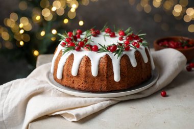 Bulanık ışıklara karşı kremalı, kızılcıklı ve biberiyeli lezzetli bir Noel pastası.