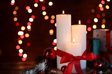 Yakıcı mumlar, köknar ağacı dalları, hediye kutuları ve takılar siyah arka planda bulanık ışıklarla, yazı için yeri olan yakın plan. Noel tebrik kartı.