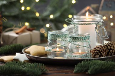 Noel fenerleri, kurabiyeler ve ahşap masanın üzerindeki şenlikli dekor arka planda bulanık ışıklarla, yakın plan. Bokeh etkisi