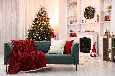 Şömine, kanepe, Noel ağacı ve şık bir odada şenlikli bir dekor.