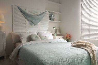 Büyük yataklı, yastıklı ve lambalı şık bir yatak odası. İç tasarım