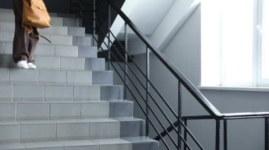 İçeride merdivenlerde sırt çantalı depresif genç kız.