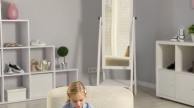 Dükkanda farklı ayakkabılar deneyen küçük bir kız. Kamera aşağı iniyor