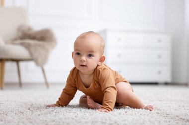 Evde yerde yatan şirin bir bebeğin portresi.