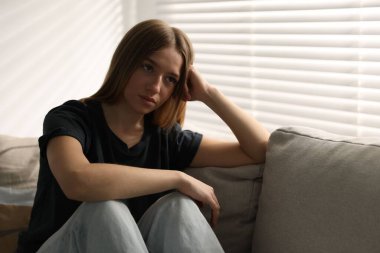 Evdeki kanepede depresif genç kız.