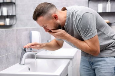 Banyo lavabosundan muzdarip bir adam.