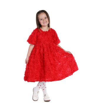 Güzel elbiseler ve beyaz arka planda ayakkabılar giyen küçük bir kız.