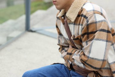 Genç adam mide ağrısı ve mide bulantısı çekiyor. Yakın plan. Metin için boşluk