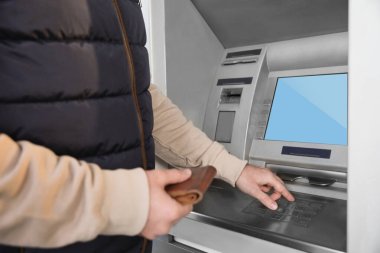 Cüzdanı olan bir adam modern para makinesini kullanıyor, yakın plan. ATM