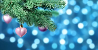 Mavi arka planda bulanık ışıklara karşı süslemeli Noel ağacı dalı, bokeh etkisi. Pankart tasarımı