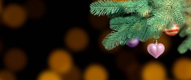 Karanlık arka planda bulanık ışıklara karşı süslemeli Noel ağacı dalı, bokeh etkisi. Pankart tasarımı