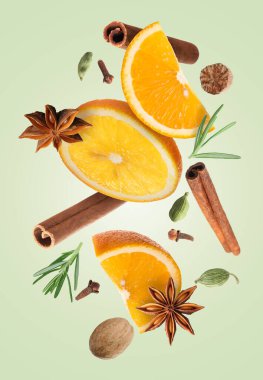 Noel için portakal dilimleri ve baharatlar soluk yeşil arka plana dökülen sıcak şarap.