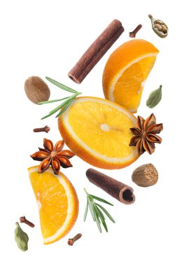 Sıcak şarap malzemeleri: beyaz zemine düşen portakal dilimleri ve baharatlar. Geleneksel Noel içkisi