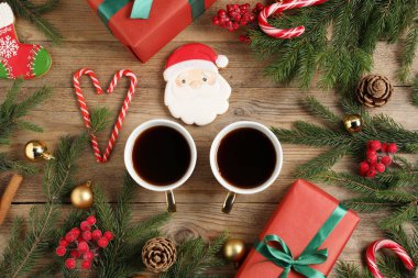 Fincanlarda romatik kahve, zencefilli kurabiye, hediye kutuları ve ahşap masada Noel süsü, düz uzanma