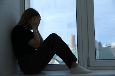 Depresyondaki genç kız evinin penceresinin yanında