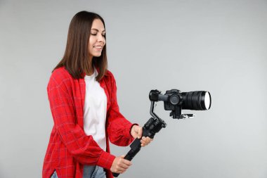 Kameraman, arka planında kamera olan titreşimli dengeleyici kullanıyor. Metin için boşluk