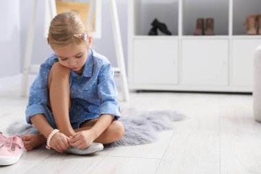 Dükkanda farklı ayakkabılar deneyen küçük bir kız. Metin için boşluk