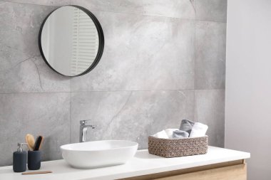 Ayna, damar lavabosu ve ev bitkisi olan şık bir banyo.