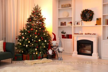 Komik cüceler, şömine ve süslü odada Noel ağacı.