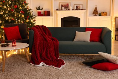 Noel ağacı, kanepe, şömine ve şenlikli dekorlu şık bir oda. İç tasarım