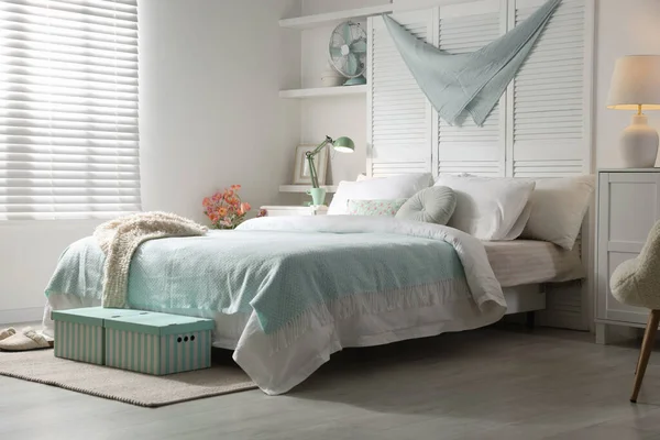 Büyük yataklı, yastıklı ve lambalı şık bir yatak odası. İç tasarım