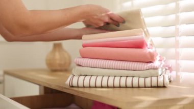 Kadın giysileri kapalı dolaba koyuyor, yakın plan.