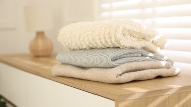 İçerideki pencerenin yanındaki dolapta temiz giysiler var, yakın çekim. Kamera içeri giriyor.