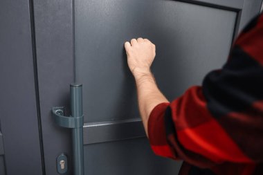 Apartman kapısını çalan adam, yakın çekim manzarası.