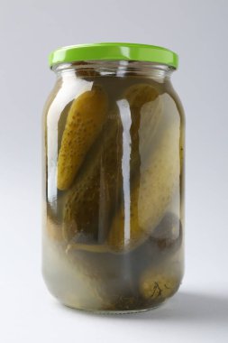 Hafif arka planda kavanozda salatalık turşusu, yakın plan.