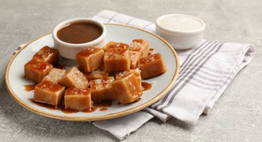 Gri desenli masada tuzlu ve karamel soslu lezzetli şekerler, yakın plan.