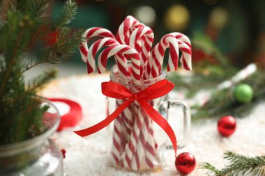 Duvarcı kavanozunda bir sürü şeker kamışı ve yapay kar üzerinde Noel dekoru, yakın plan.