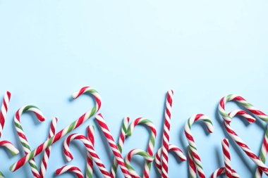 Açık mavi arkaplanda şeker kamışları, metin için yeri olan düz yataklar. Noel hediyesi