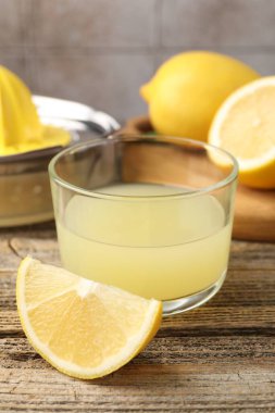 Bardakta limon suyu ve ahşap masada taze limon. Yakın plan.