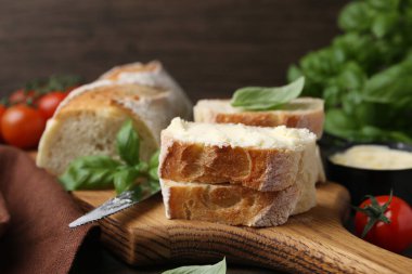 Tereyağlı, fesleğenli, domatesli ve bıçaklı ekmek dilimleri.