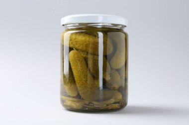 Hafif arka planda kavanozda salatalık turşusu, yakın plan.