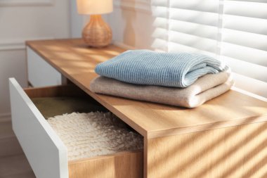 İçerideki pencerenin yanındaki dolapta temiz giysiler var, yakın plan.